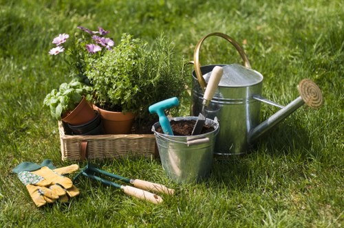 Gardener preparing a Kings Cross lawn with equipment and recycling bins